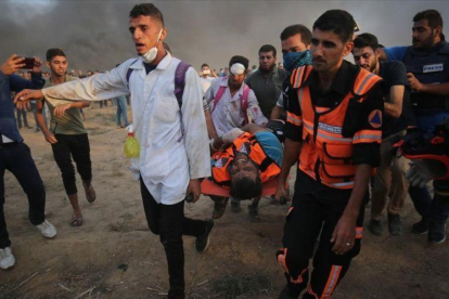 Personal sanitario palestino trasladan a un manifestante herido durante los enfrentamientos con las fuerzas israelís al este de la ciudad de Gaza.-SAID KHATIB (AFP)