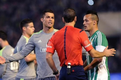 Cristiano Ronaldo protesta al árbitro Martínez Munuera durante el partido contra el Betis.-AFP / CRISTINA QUICLER
