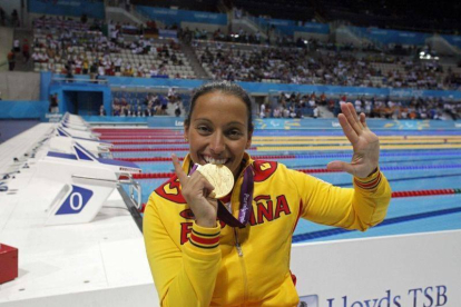 Teresa Perales mordiendo una de las medallas ganadas en los Juegos de Londres 2012.-ONCE