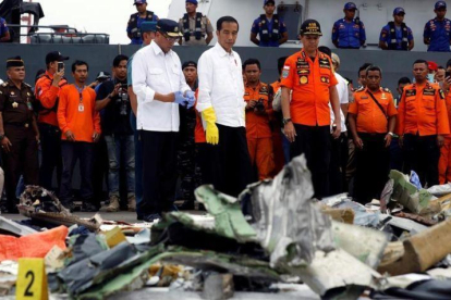 El presidente indonesio, Joko Widodo (centro), inspecciona algunos de los restos del avión de Lion Air siniestrado.-EDGAR SU (REUTERS)