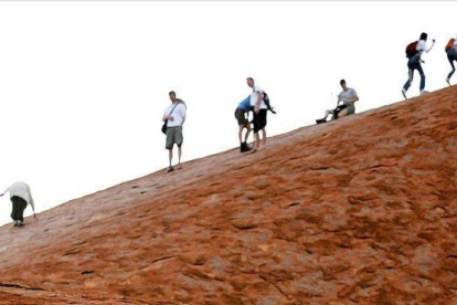 Turistas en el monte Uluru.-AFP