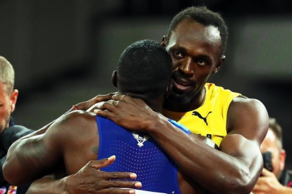 Bolt se abraza con Gatlin al final de la carrera.-EFE