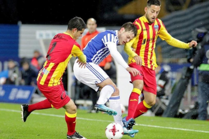 Bautista, de la Real, pelea un balón entre dos jugadores del Lleida.-EFE / GORKA ESTRADA