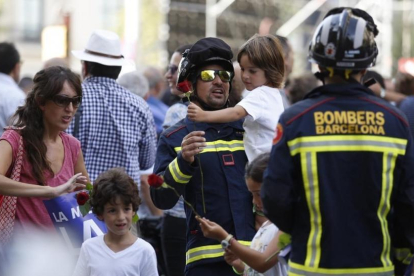 Un bombero con un niño en brazos durante la marcha-ALBERT BERTRÁN
