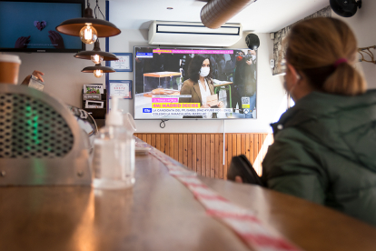 Una persona mirando la televisión en el interior de un bar mientras espera a que le sirvan.-GONZALO MONTESEGURO