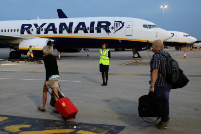 Pasajeros se dirijen a un avión de la compañia Ryanair en un aeropuerto de Londres-KEVIN COOMBS (REUTERS
