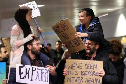 Adin y Meryem sentados sobre los hombros de sus padres, Jordan Bendant-Appell, un rabino, y Faith Yildrim, un musulmán, en una manifestación en Chicago.-Chicago Tribune