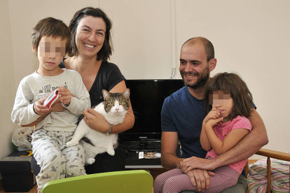 María Llull y Jorge Piña en el salón de su nueva casa junto con sus hijos, Nico y Alba y su gato ‘Tomás’. / VALENTÍN GUISANDE-