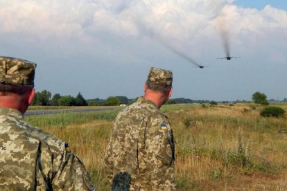 Dos soldados ucranianos contemplan el vuelo de dos Sukhoi rusos.-REUTERS/ STRINGER