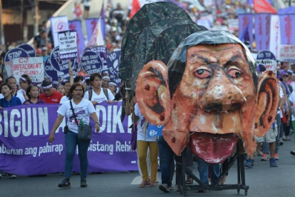 Manifestantes en Manila durante el Día Internacional de la Mujer empujando una efigie del presidente filipino, Rodrigo Duterte-/ TED ALJIBE (AFP)