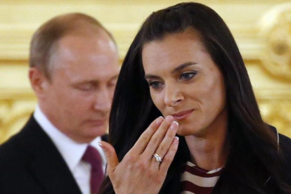 Isinbayeva, delante de Putin, en el acto de despedida del equipo olímpico.-EFE / YURY KOCHETKOV