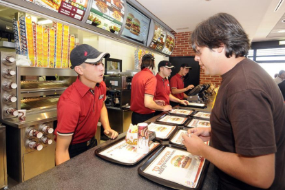 Jóvenes trabajando en un restaurante de comida rápida.-VALENTÍN GUISANDE