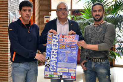 Luis Oliver, Modesto Fernández y Javier Arribas con el cartel de la XIX Carrera de Navidad. / Álvaro Martínez-