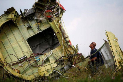 Un investigador inspecciona los restos del avión malasio siniestrado.-MAXIM ZMEYEV (REUTERS)