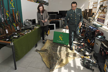 Heredia y Velarde en una de las dependencias llenas de objetos recuperados, con las armas de fuego a la derecha de la imagen. / VALENTÍN GUISANDE-