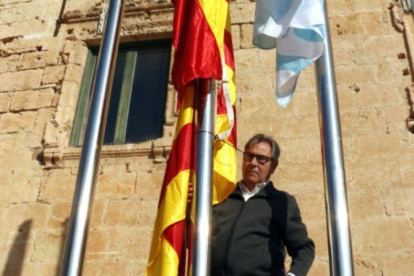 El alcalde de Torredembarra, Eduard Rovira, junto al mástil en que ha colocado la bandera española y, debajo, la 'senyera'.-ACN
