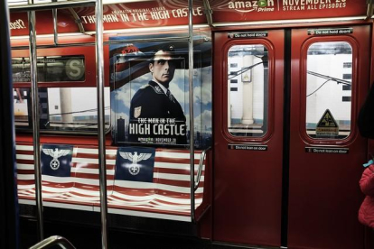 El águila nazi sobrepuesta sobre la bandera de EEUU en la promoción de la serie de Amazon 'The man in the high castle', ayer en el metro de Nueva York.-AFP / SPENCER PLATT
