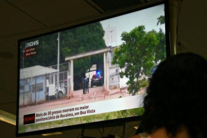 Una mujer sigue la noticia de la masacre en la prisión de Brasil a través de la televisión.-AFP / VANDERLEI ALMEIDA