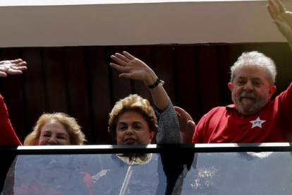 Lula (derecha), Rousseff y la esposa del expresidente, Marisa, saludan desde una ventana de la casa de la parella, en Sao Bernardo do Camopo (Brasil), el 5 de marzo.-REUTERS / PAULO WHITAKER