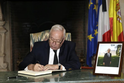 El ministro de Asuntos Exteriores, José Manuel García-Margallo, firma en el libro de condolencias instalado en el vestíbulo de la residencia del embajador de Francia en España, Yves Saint-Geours, tras los atentados terroristas de ayer en París.-EFE/Zipi