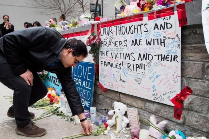 Un hombre coloca una flor en el memorial improvisado a las víctimas del atropello en Toronto.-/ NATHAN DENETTE / AP