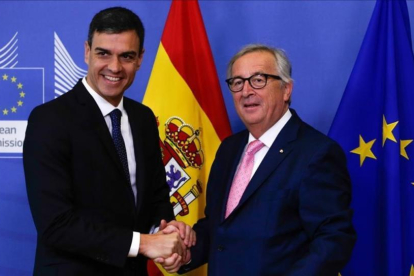 Sánchez y Juncker se saliudan antes de la reunión que han mantenido previa a la cumbre de la UE.-AFP
