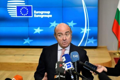 Luis de Guindos atiende a la prensa ayer, en Bruselas, tras la reunión del Eurogrupo.-/ AFP / JOHN THYS