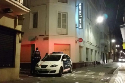 Una patrulla de los Mossos vigila la calle de Sant Josep, donde está el hotel Vila. En el suelo, papeletas de votación.-ÓSCAR HERNÁNDEZ