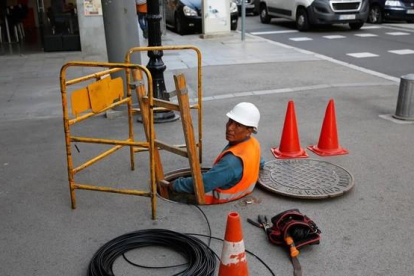 Trabajador instalando la fibra óptica en el Poblenou de Barcelona.-ÁLVARO MONGE (EL PERIÓDICO)
