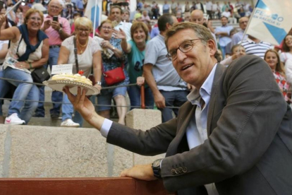 Alberto Núñez Feijóo saluda a varios simpatizantes que le regalaron una tarta por su cumpleaños, durante la campaña cara a las elecciones gallegas.-EFE