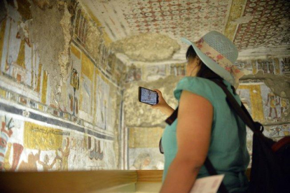 Una mujer fotografía el interior de una de las tumbas restauradas en Dra Abu al Naga, en Luxor.-EPA