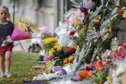 Una niña pone flores en el memorial de recuerdo del atentado en Christchurch, el pasado mes de marzo.-VINCENT THIAN (AP)