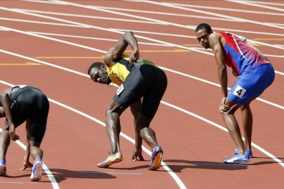 Bolt, a punto de recibir el último testigo del 4x100 jamaicano.-AP / ALASTAIR GRANT