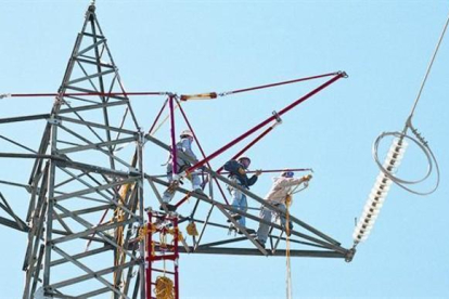 Un grupo de trabajadores preparan la sustitución del tendido de electricidad de una torre de alta tensión-EL PERIÓDICO / ARCHIVO