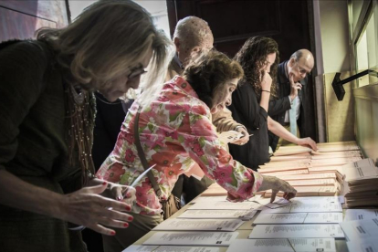 Un grupo de electores revisa papeletas en unas elecciones.-MIGUEL LORENZO