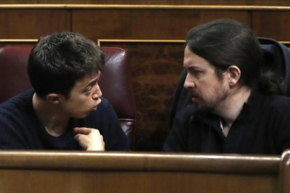Los máximos dirigentes de Podemos, Iñigo Errejón y Pablo Iglesias, discuten en sus escaños del Congreso.-EFE