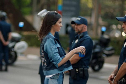 Kendall Jenner en el nuevo anuncio de Pepsi se detiene ante un policía y le ofrece el refresco en plena manifestación.-TWITTER
