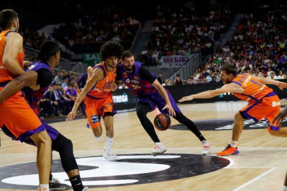 El barcelonista Mirotic (c) intenta culminar una jugada ante Valencia Basket.-EFE
