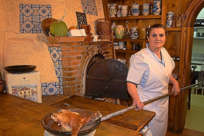 Isabel Alameda, con un cuarto de lechazo asado, uno de los platos más representativos de la casa.-ARGI
