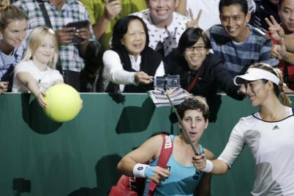 Garbiñe Muguruza y Carla Suárez celebrando su victoria junto a los aficionados presentes en Singapur-REUTERS / JEREMY LEE