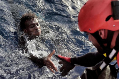 Un miembro de la oenegé Proactiva Open Arms rescata a un inmigrante en el Mediterráneo, frente a la costa libiam en octubre del 2016.-ARIS MESSINIS