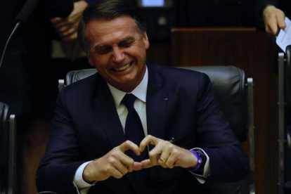 El presidente brasileño, Jair Bolsonaro, muestra un corazón con sus dedos durante su toma de posesión en el Parlamento.-MARCELO CHELLO (EFE)