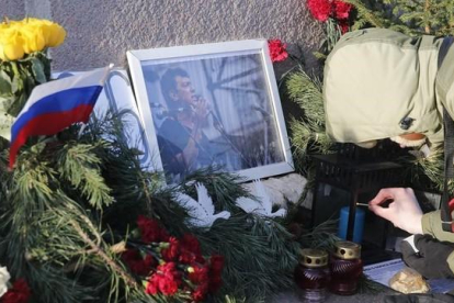 Un hombre enciende una vela en el lugar donde cayó abatido Nemtsov, en una imagen de archivo, el pasado 29 de diciembre.-REUTERS / MAXIM ZMEYEV