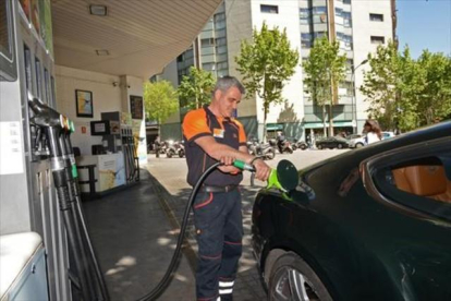 Un empleado llena un depósito en una gasolinera de Barcelona.-MÓNICA TUDELA