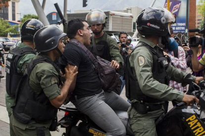 Imagen de archivo de miembros de la Guardia Nacional Bolivariana de Venezuela, detieneniendo a un joven en 2012.-EFE / MIGUEL GUTIÉRREZ