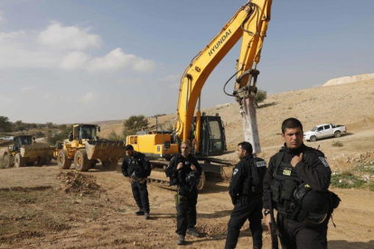 Policías israelís montan guardia junto a excavadoras tras demoler las casas del poblado beduino de Um al Hiran, este miércoles.-AP / TSAFRIR ABAYOV
