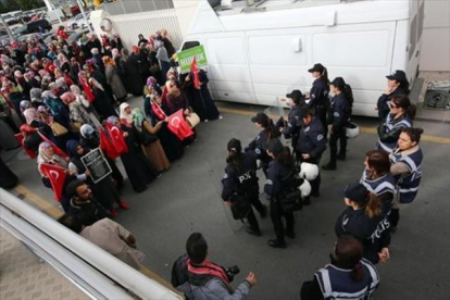 Mujeres policía vigilan a un grupo de manifestantes frente a la sede del hólding Koza Ipek, en Ankara.-AP