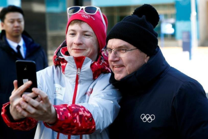 El presidente del COI, Thomas Bach, se hace un selfi con una voluntaria en Pieonchang.-EFE