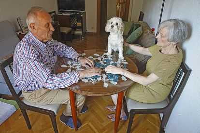 Charo y Fernando, diagnosticado hace cuatro años de Alzheimer, juegan, como cada tarde desde que cerró el centro de la asociación, una de sus partidas de dominó.- J. M. LOSTAU
