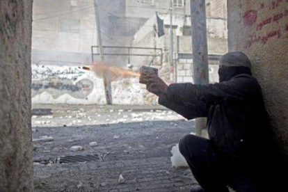 Un palestino lanza un petardo a las fuerzas de seguridad israelís.-Foto: EFE / ABIR SULTAN
